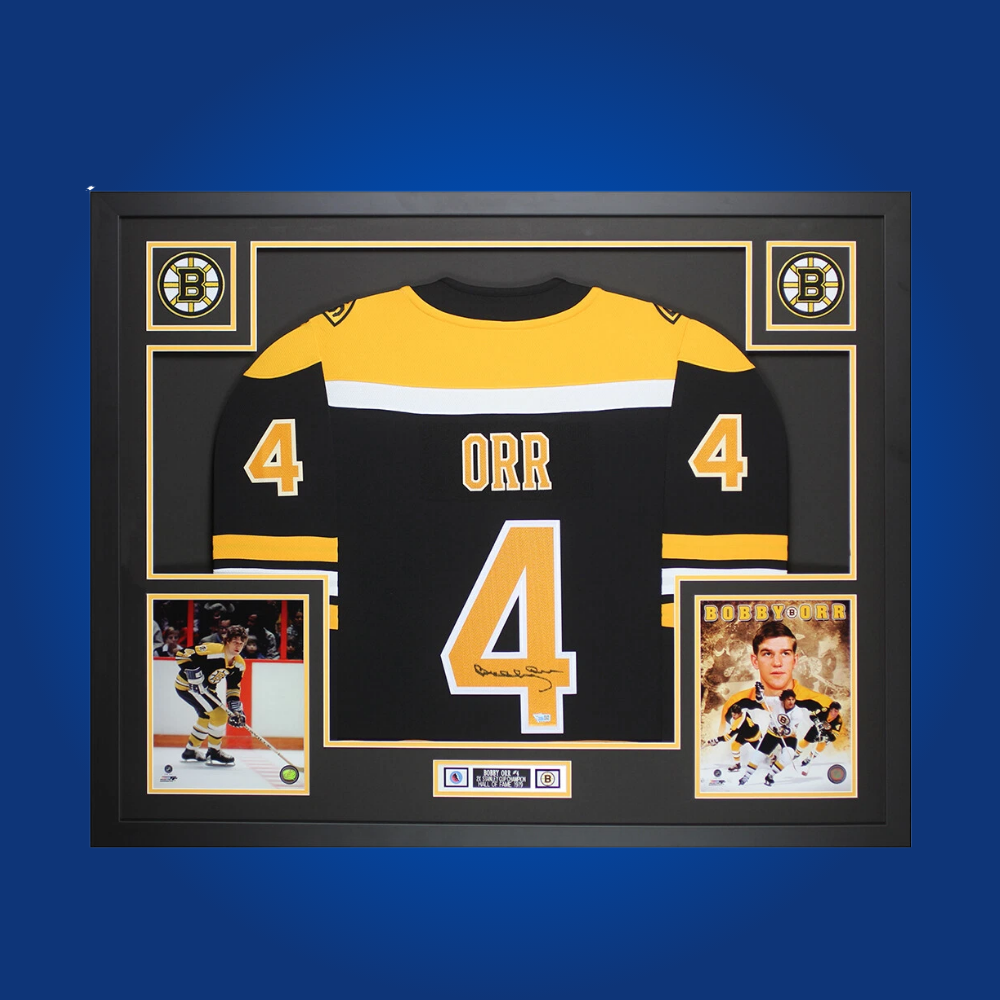 Bobby Orr’s hand-signed and framed black Boston Bruins jersey. A rare collectible for Bruins fans, honoring one of hockey’s greatest defensemen and his iconic contributions to the game.