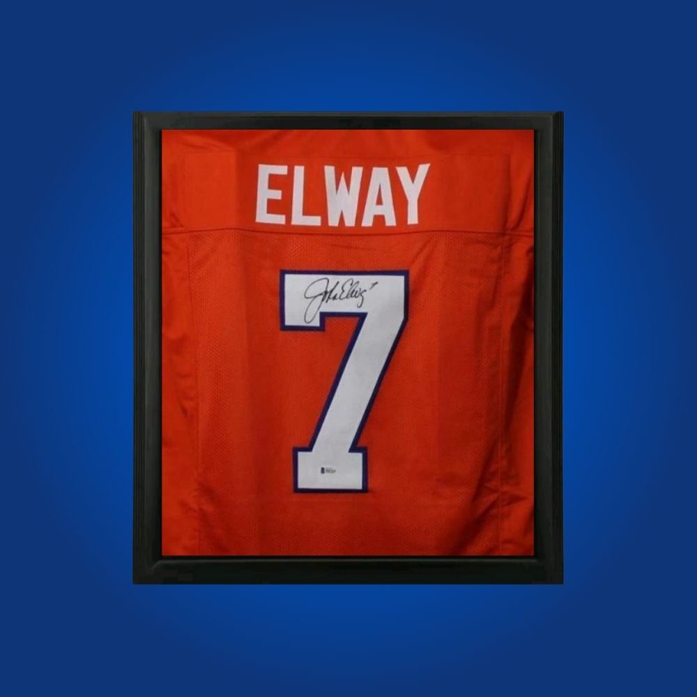 John Elway hand-signed orange framed Denver Broncos jersey, showcasing signature and official team graphics. A unique collectible for Broncos fans and Elway memorabilia collectors. Includes Certificate of Authenticity. Images may differ for catalog uniformity.