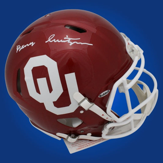 Autographed Oklahoma Sooners full size Authentic Helmet signed by Barry Switzer, featured on a white background. SportsMarkets collectible product image.