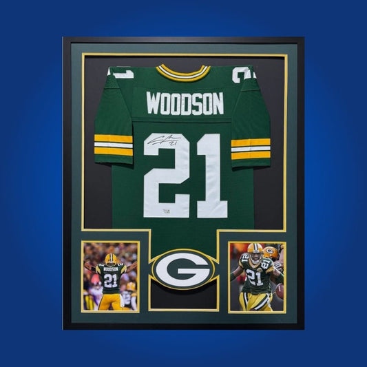 Framed Charles Woodson autographed Packers jersey with two action shots and COA.