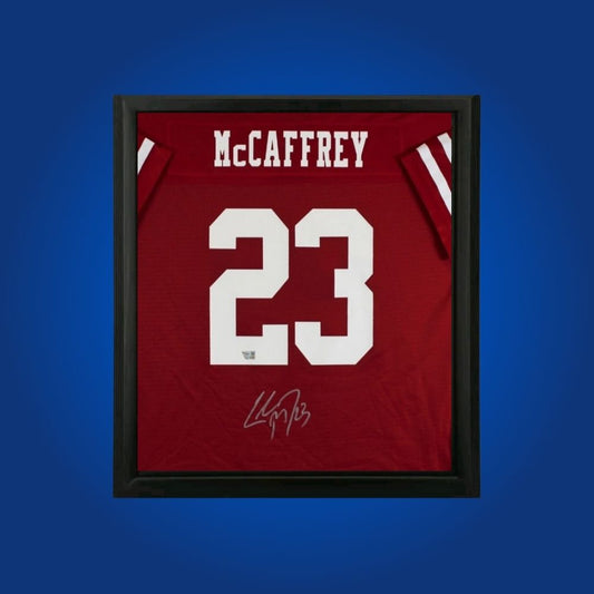 Christian McCaffrey hand-signed red framed San Francisco 49ers jersey, showcasing signature and official team graphics. A unique collectible for 49ers fans and McCaffrey memorabilia collectors. Includes Certificate of Authenticity. Images may differ for catalog uniformity.