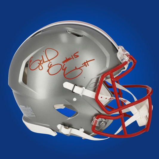 Autographed Ohio State Buckeyes full size Authentic Helmet signed by Ezekiel Elliott, shown against a white background for product clarity. SportsMarkets exclusive memorabilia image.