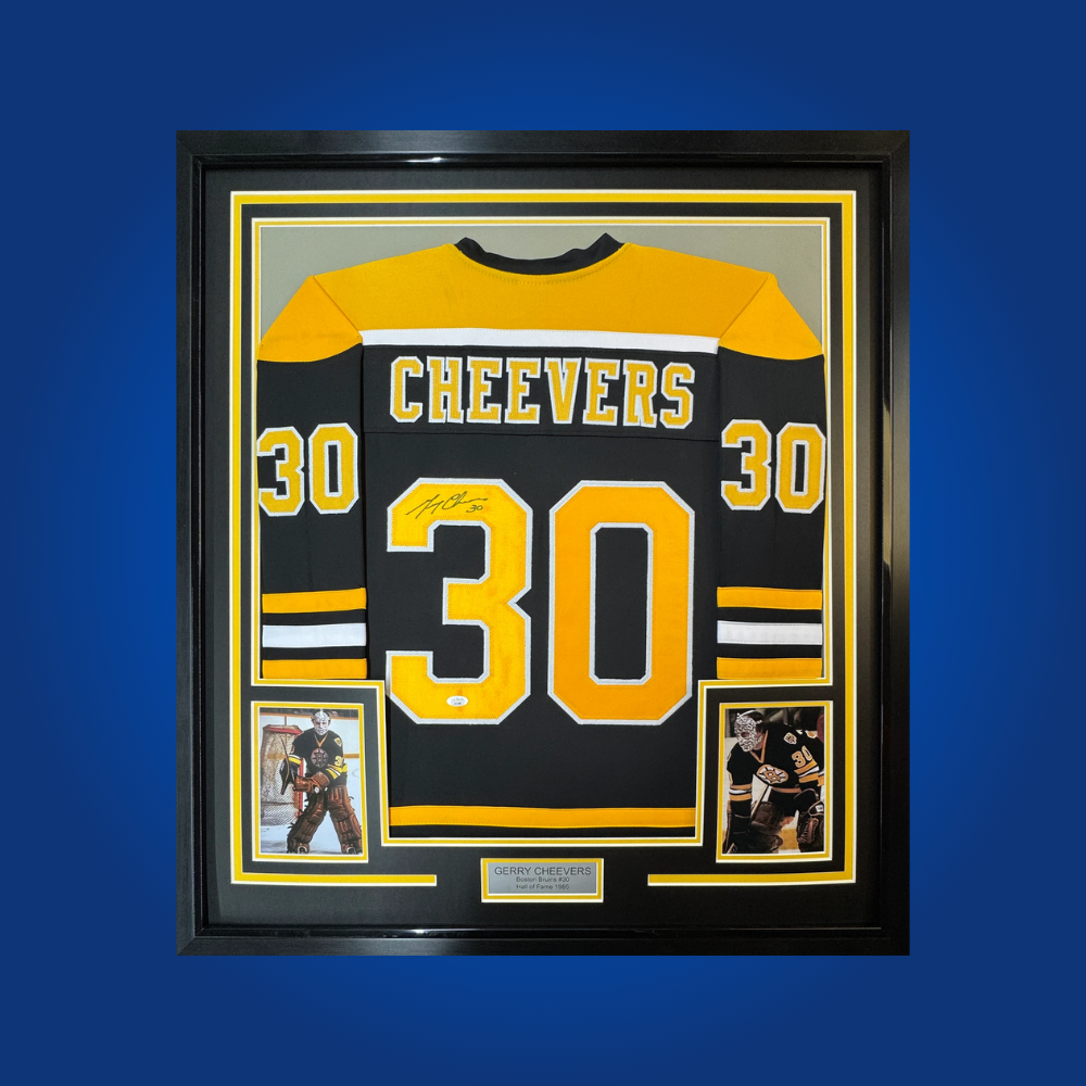Gerry Cheevers’ signature on this full framed Boston Bruins jersey pays tribute to a Hall of Fame goaltender. A prized collectible for Bruins supporters and hockey memorabilia aficionados.