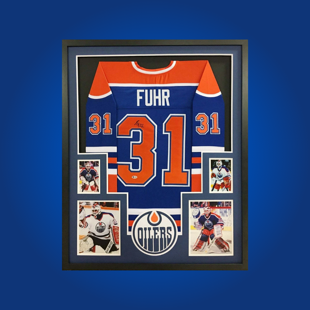 Grant Fuhr’s signed full framed Edmonton Oilers blue jersey pays tribute to a Hall of Fame goaltender, offering collectors a piece of Oilers history and championship glory.