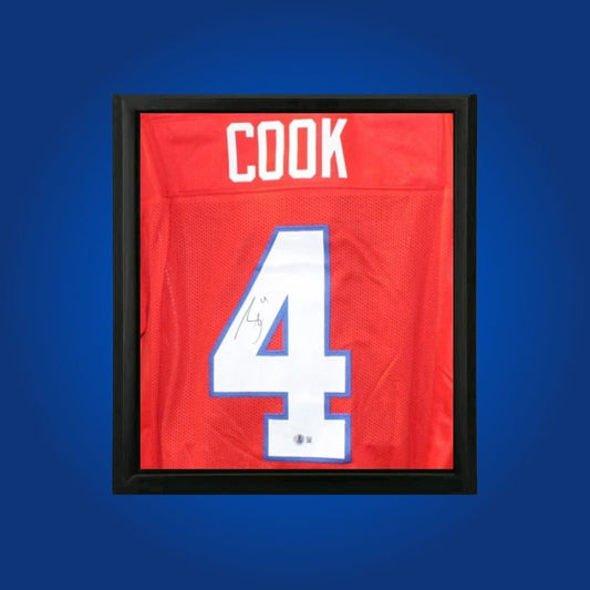 James Cook hand-signed red framed Buffalo Bills jersey, showcasing signature and official team graphics. A unique collectible for Bills fans and Cook memorabilia collectors. Includes Certificate of Authenticity. Images may differ for catalog uniformity.