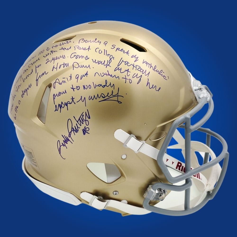 Autographed Notre Dame Fighting Irish full size Authentic Helmet signed by Rudy Ruettiger, displayed on a white backdrop. SportsMarkets collectible product image.