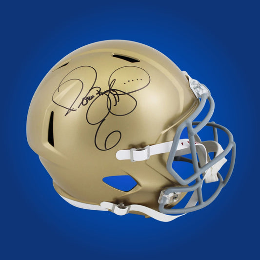 Autographed Notre Dame Fighting Irish full size replica helmet signed by Rudy Ruettiger, displayed on a white backdrop. SportsMarkets collectible product image.